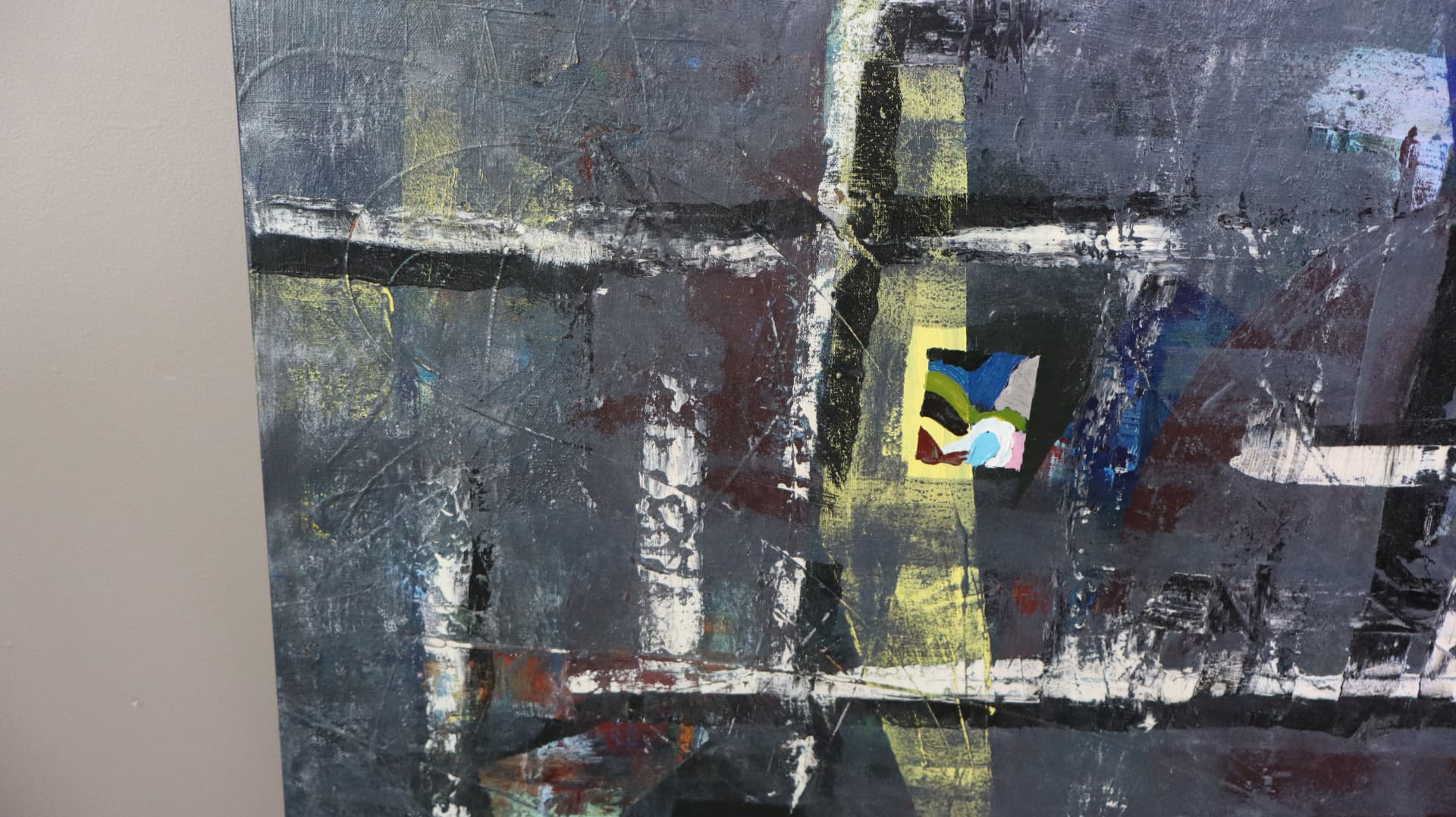 Laws — close-up detail of layered gray-black grid with yellow, blue, and rust intrusions